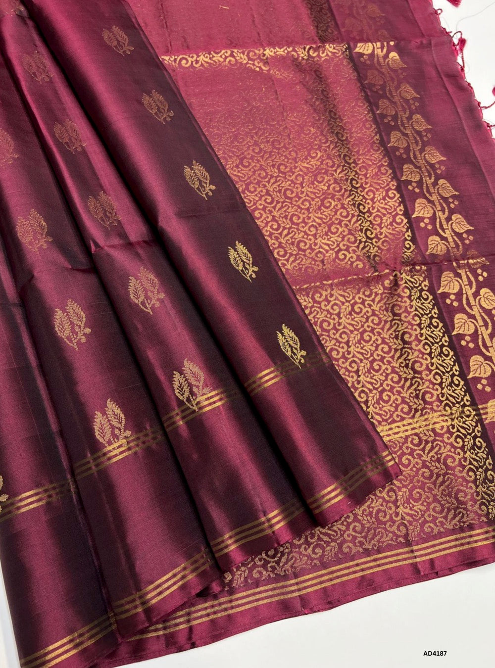 The Deep Burgundy Soft Silk Saree is a regal handwoven creation that radiates sophistication and cultural grandeur. The deep burgundy shade symbolizes devotion, prosperity, and timeless elegance, making it an ideal choice for weddings, temple ceremonies, and festive occasions. Enhanced with pure gold zari borders and a lustrous drape, this saree reflects the artistry of Kanchipuram weaving, offering a graceful blend of tradition and modern refinement. Its rich tone pairs beautifully with gold jewelry, ensur
