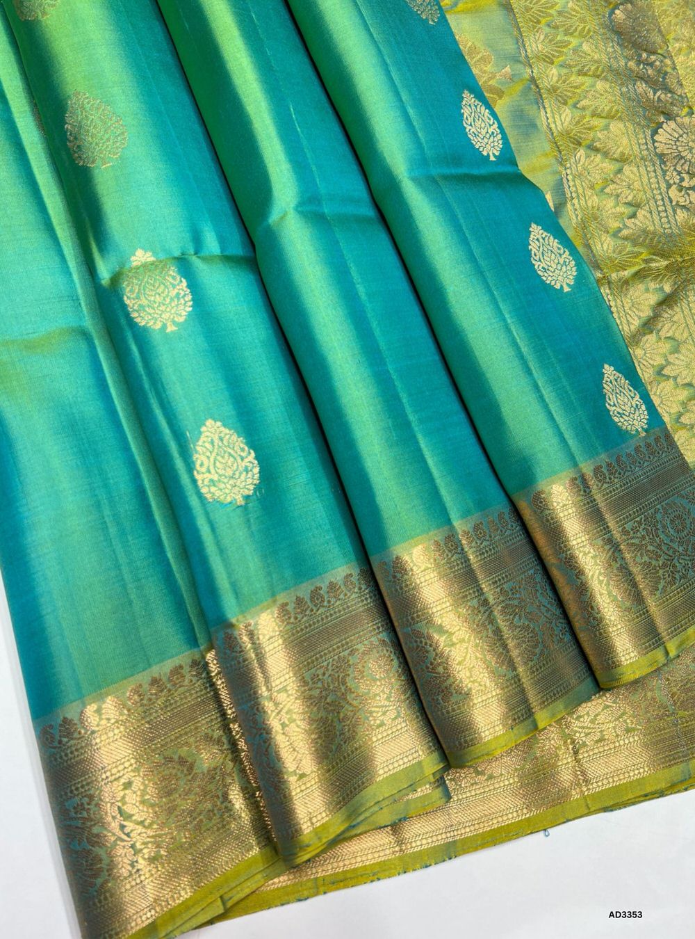 "Handwoven Dual Tone Green body with coordinated pallu Bhutta Jacquard Border Soft Silk Saree featuring gold zari motifs and borders"