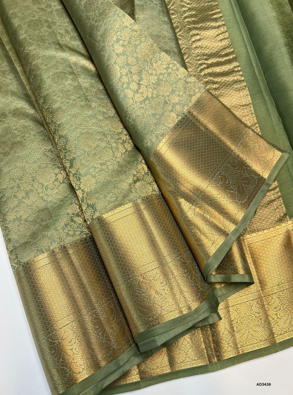 The Elachi Kanjeevaram Silk Saree is a graceful handwoven masterpiece featuring a serene cardamom‑green body paired with a rich traditional zari border. The classic Kanjeevaram weaving style brings depth, heritage, and grandeur to the saree, making it perfect for weddings, festive occasions, and cultural celebrations. Its subtle elegance and traditional craftsmanship make it a timeless wardrobe treasure.