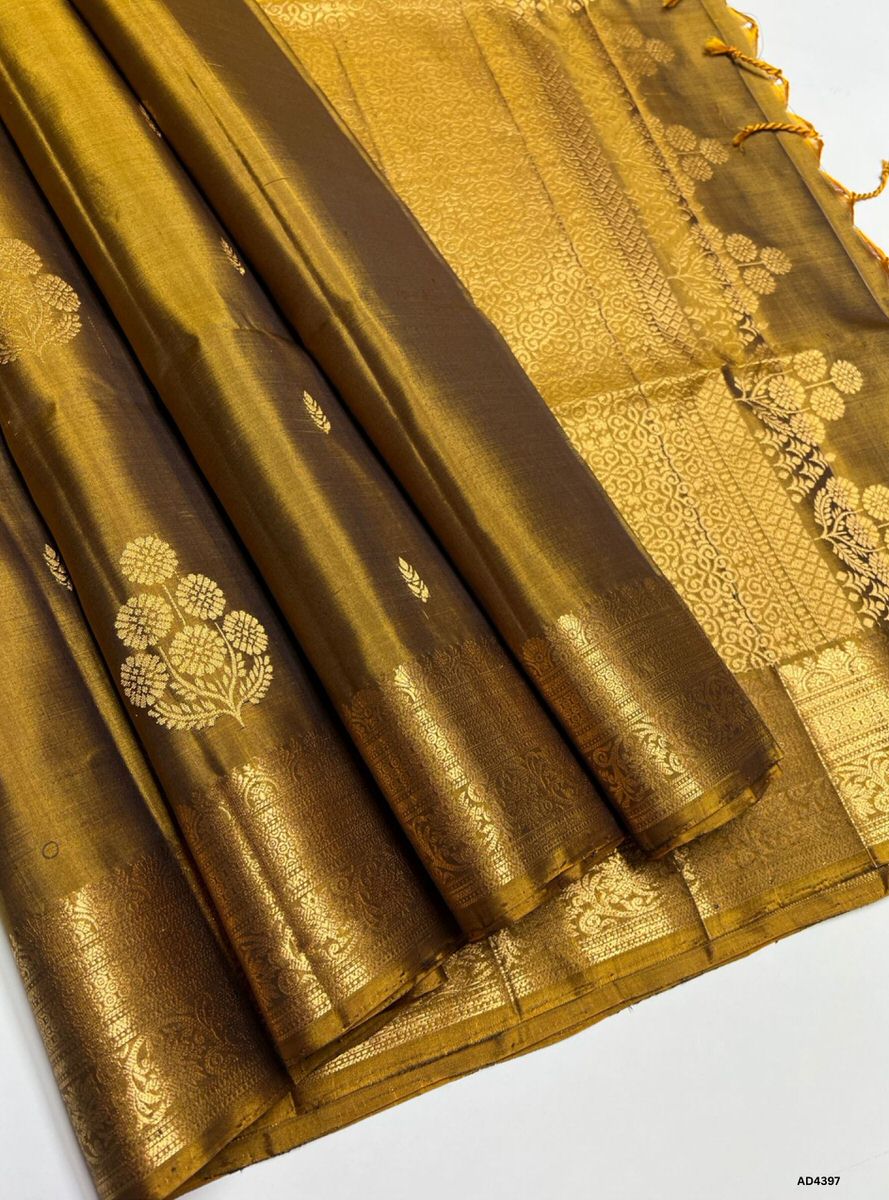 The Golden Brown Kanchi Border Soft Silk Saree is a refined handwoven creation that radiates festive charm and cultural richness. The golden brown shade conveys warmth, prosperity, and timeless elegance, while the temple‑inspired Kanchi border enriched with pure gold zari elevates its grandeur. With its lustrous drape and coordinated blouse, this saree is perfect for weddings, temple ceremonies, and festive occasions. A timeless masterpiece, it blends earthy richness with the heritage of Kanchipuram weaving