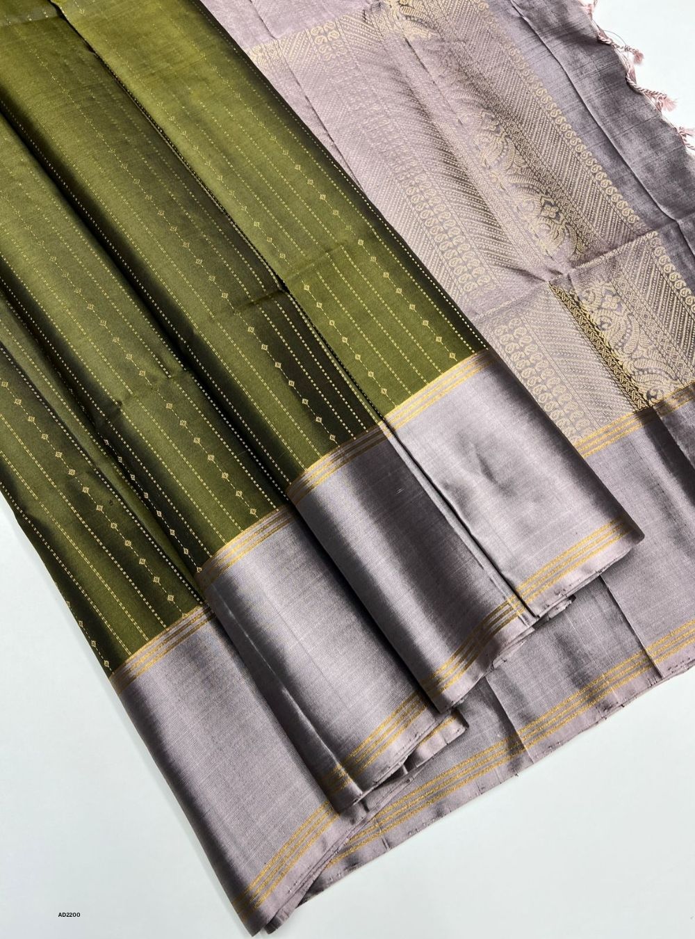Gray and green saree with a subtle pattern on a light gray background