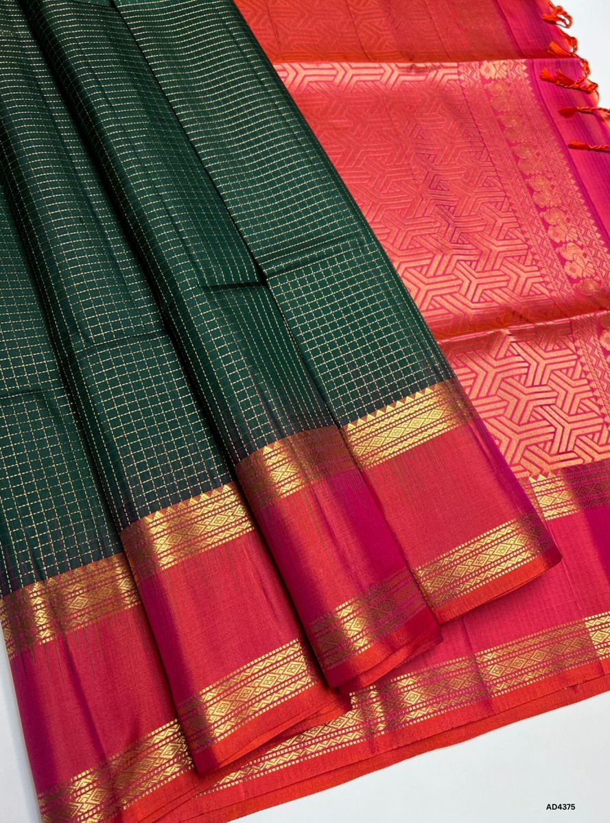 The Green & Orangish Pink Checkered Retta Pet Soft Silk Saree is a radiant handwoven creation that embodies festive charm and cultural grandeur. The green shade symbolizes prosperity, devotion, and auspiciousness, while the orangish pink checks add celebratory vibrance, joy, and regal depth. Enhanced with pure gold zari borders and a lustrous drape, this saree is perfect for weddings, temple ceremonies, and festive occasions. A timeless masterpiece, it blends vibrant dual tones with the heritage Retta Pet c