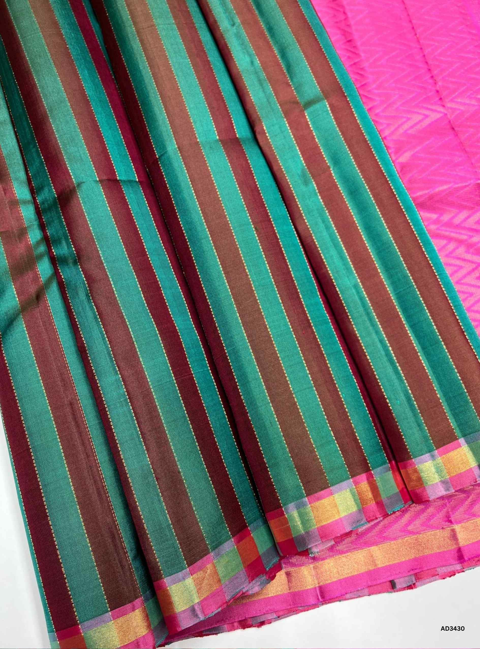 The Green & Pink Soft Silk Saree is a handwoven beauty that celebrates minimalism with its plain green body, while the vibrant pink pallu enriched with zari accents adds a lively contrast. This dual‑tone combination makes the saree perfect for festive occasions, weddings, and cultural gatherings, blending simplicity with traditional elegance.
