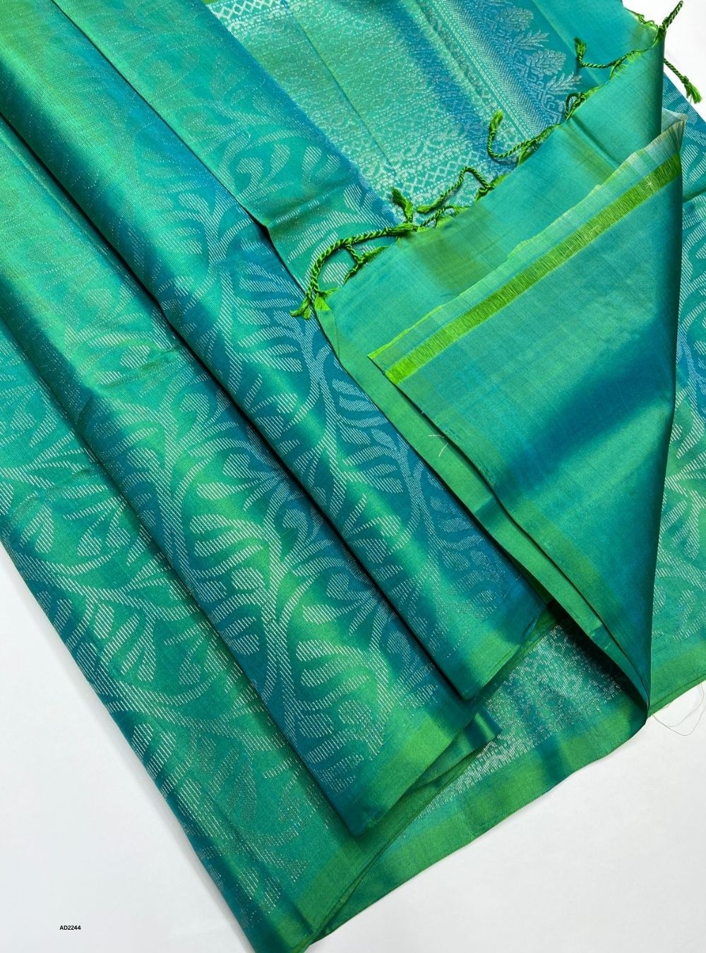 Green and blue fabric with leaf patterns on a white background