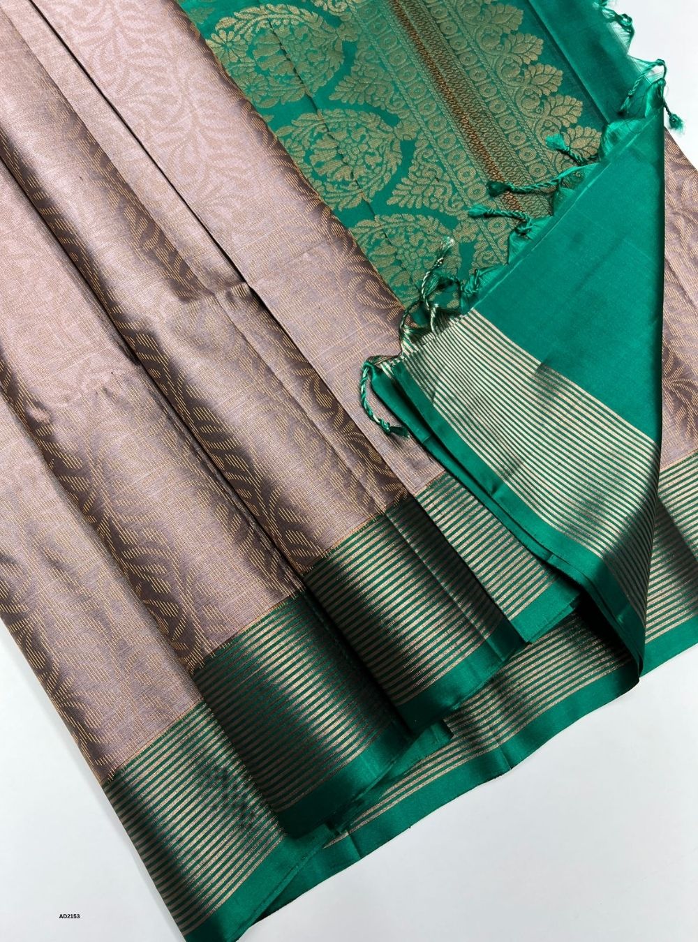 Green and brown saree with a decorative border on a white background