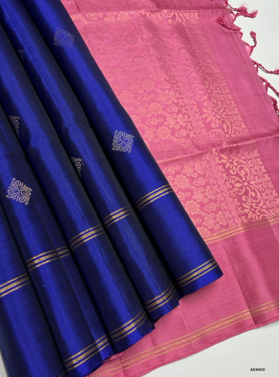 The Ink Blue & Pink Soft Silk Saree with Bhutta motifs is a radiant handwoven creation that embodies festive charm and cultural richness. The ink blue shade conveys devotion, sophistication, and timeless elegance, while the pink contrast adds celebratory vibrance, femininity, and regal warmth. The bhutta motifs woven across the body enhance its traditional appeal, while zari borders and pallu lend grandeur. Perfect for weddings, temple ceremonies, and festive occasions, this saree reflects South Indian craf