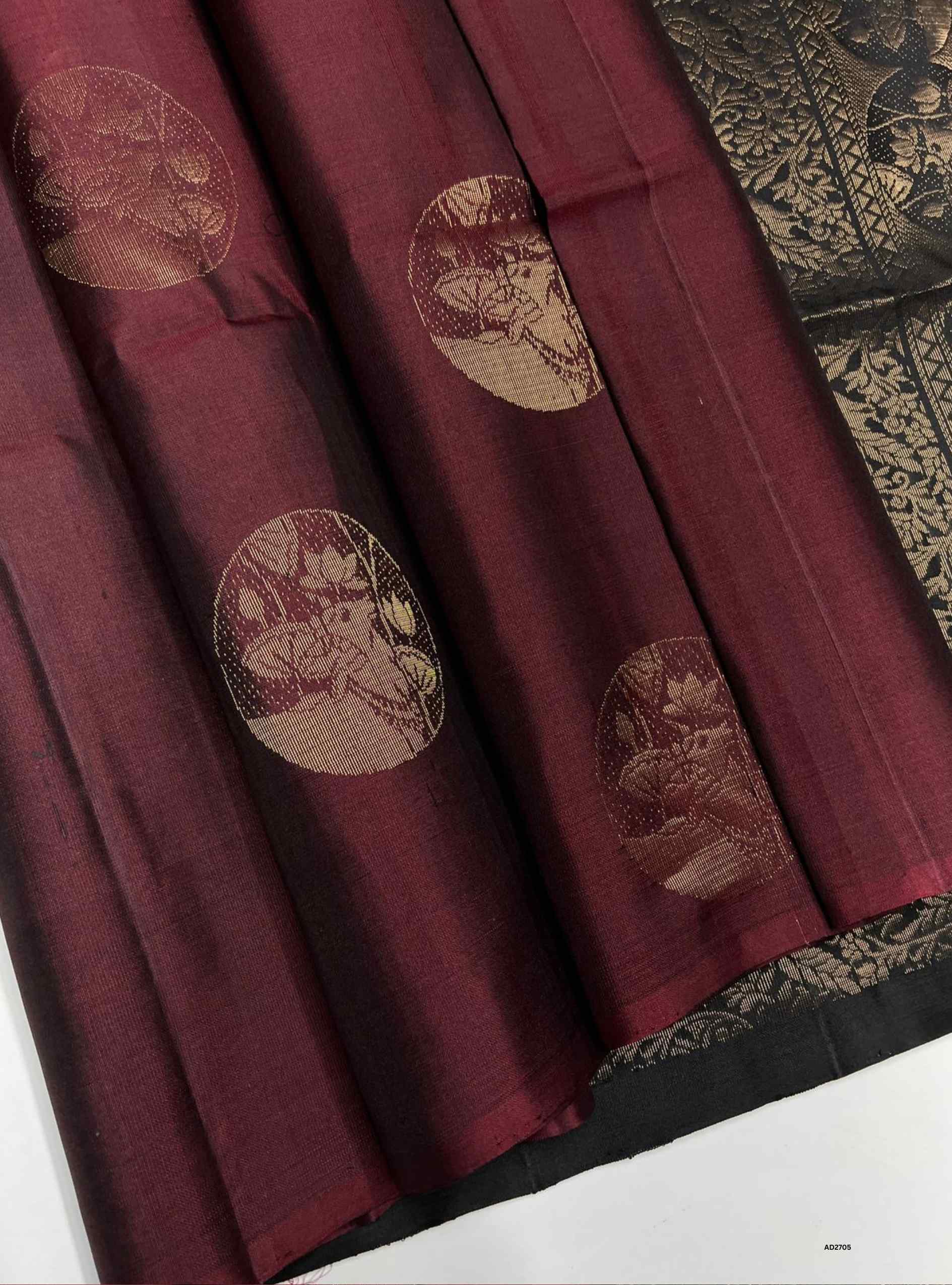 Maroon fabric with gold circular patterns 