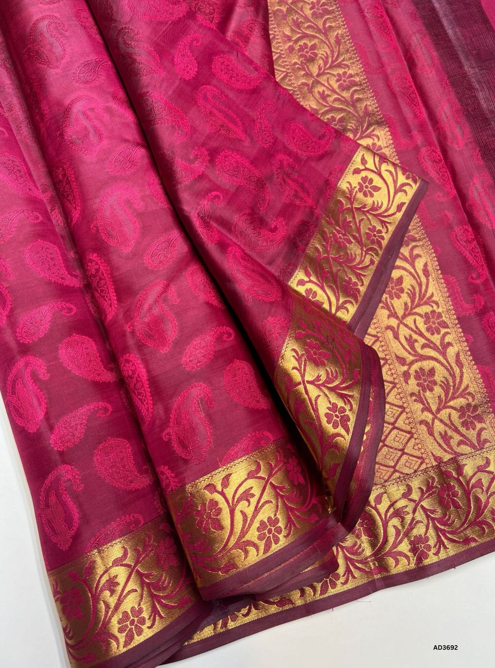 The Mulberry Pink Soft Silk Saree is a radiant handwoven creation featuring a luminous mulberry pink body enriched with shimmering zari. Its coordinated border and pallu showcase the intricate Kanchi style border, adding grandeur and traditional charm. Perfect for weddings, festive occasions, and cultural gatherings, this saree blends vibrant brilliance with timeless Kanchi craftsmanship.