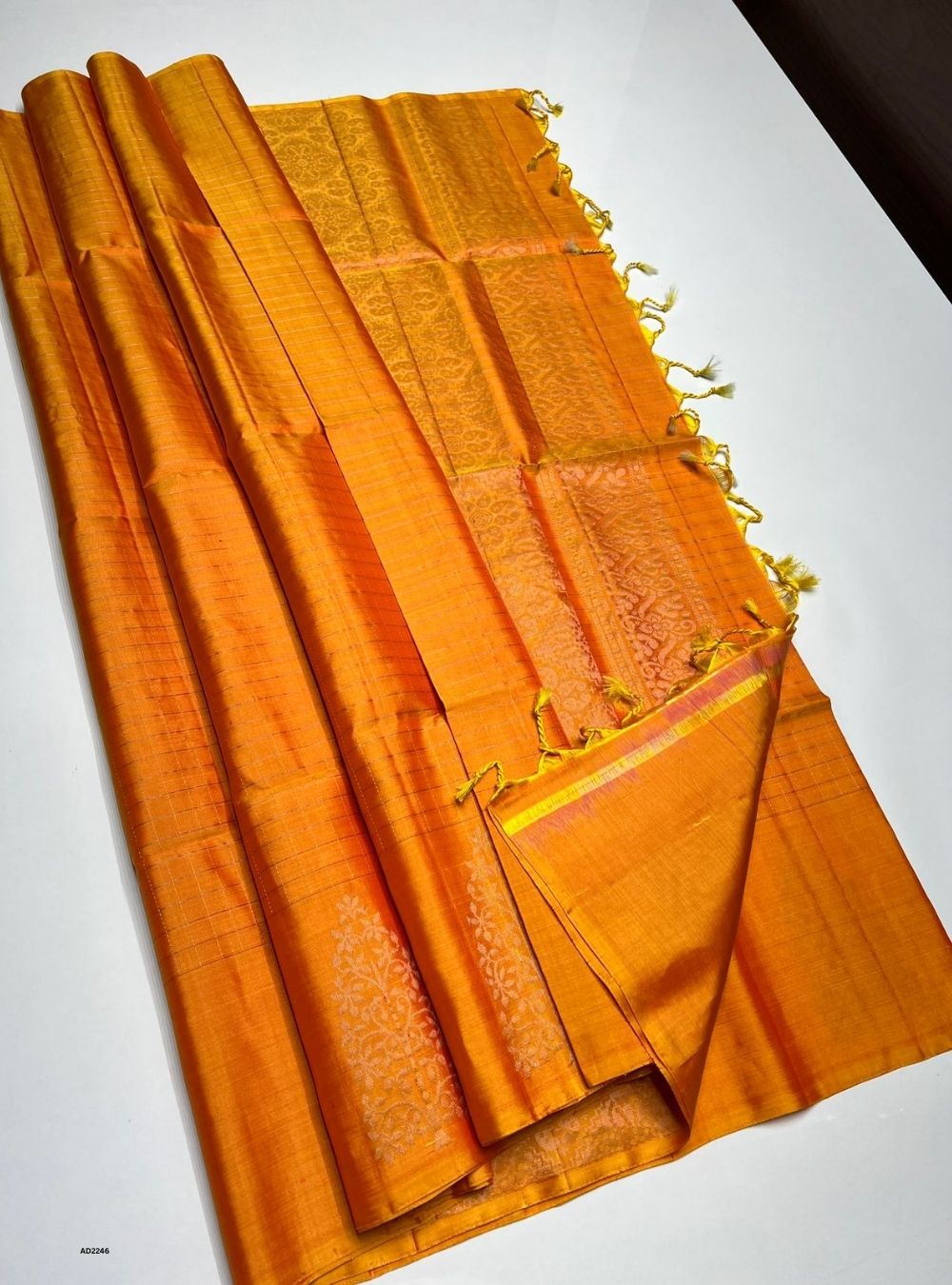 Orange fabric with gold trim on a white background