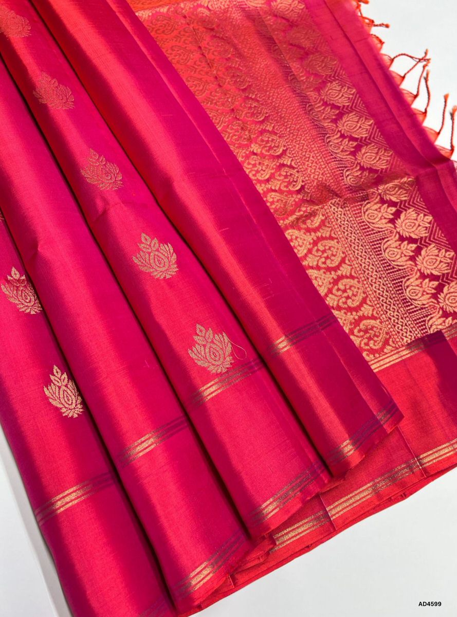 The Orangish Pink Bhutta Soft Silk Saree with Pure Gold Zari is a festive handwoven creation that radiates cultural charm and graceful brilliance, making it ideal for weddings, temple ceremonies, and traditional celebrations.