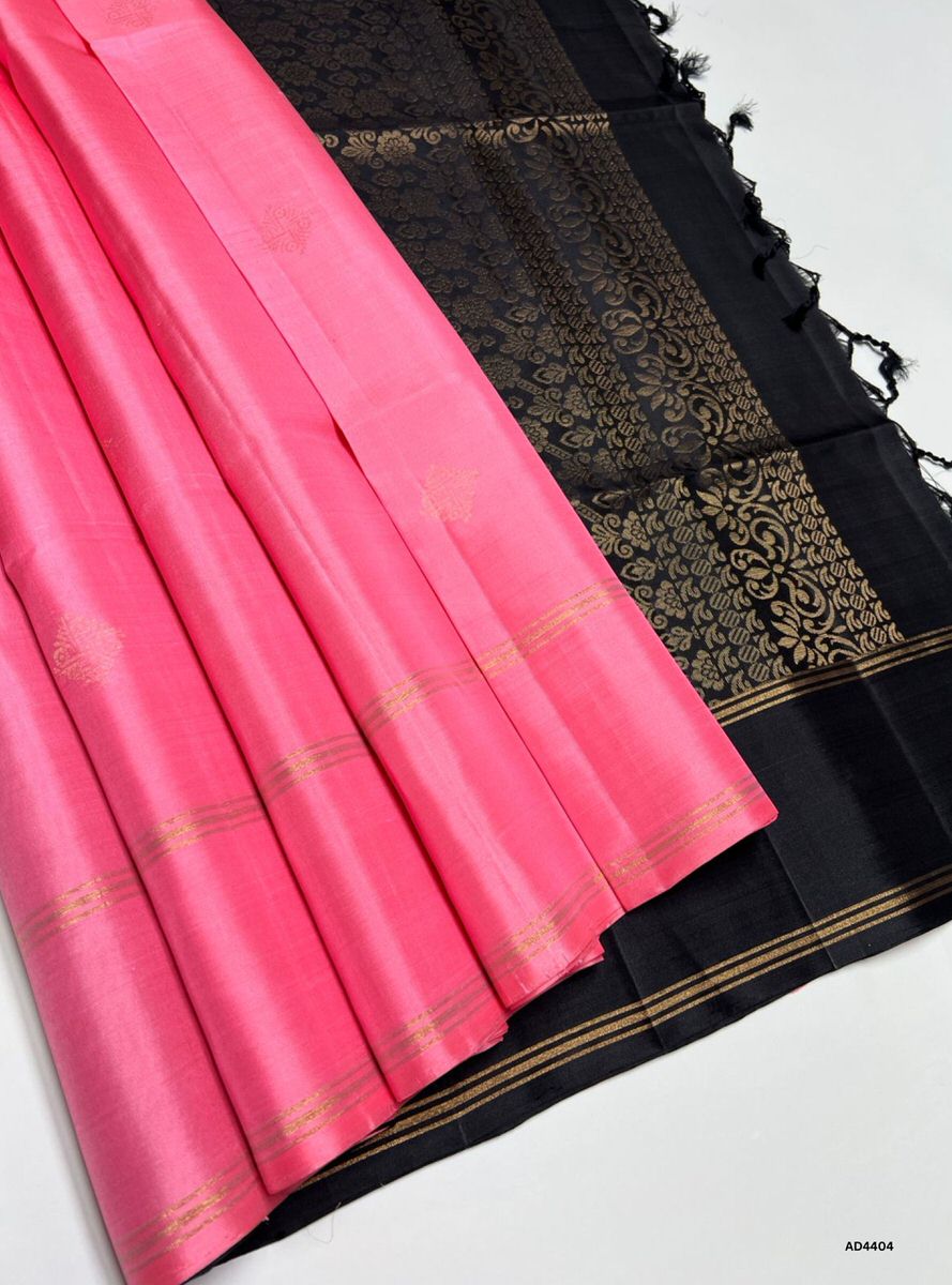 The Pink & Black Soft Silk Saree with Bhutta motifs is a radiant handwoven creation that embodies festive charm and cultural richness. The pink shade conveys joy, femininity, and celebratory warmth, while the black contrast adds sophistication, depth, and regal elegance. The bhutta motifs woven across the body enhance its traditional appeal, while zari borders and pallu lend grandeur. Perfect for weddings, temple ceremonies, and festive occasions, this saree reflects South Indian craftsmanship with a striki