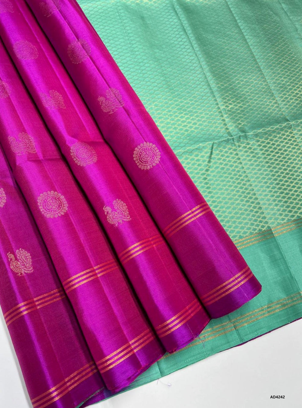 The Pink & Rama Green Bhutta Soft Silk Saree is a radiant handwoven creation that celebrates festive charm and cultural heritage. The pink shade conveys joy, femininity, and celebratory warmth, while the Rama green adds prosperity, devotion, and timeless elegance. The bhutta motifs scattered across the body enrich its traditional appeal, while the zari border and lustrous drape make it versatile for weddings, temple ceremonies, and festive occasions. A timeless piece of artistry, it blends motif‑rich weavin