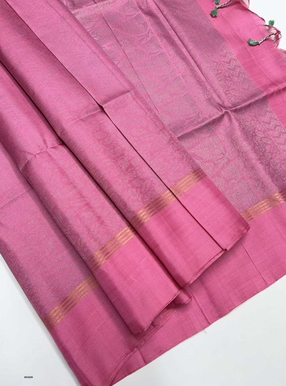 Pink saree with a subtle pattern on a white background