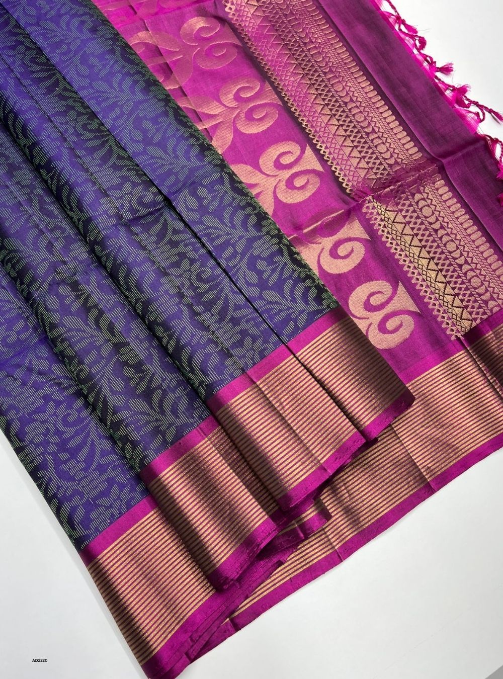 Purple and pink saree with intricate patterns on a white background