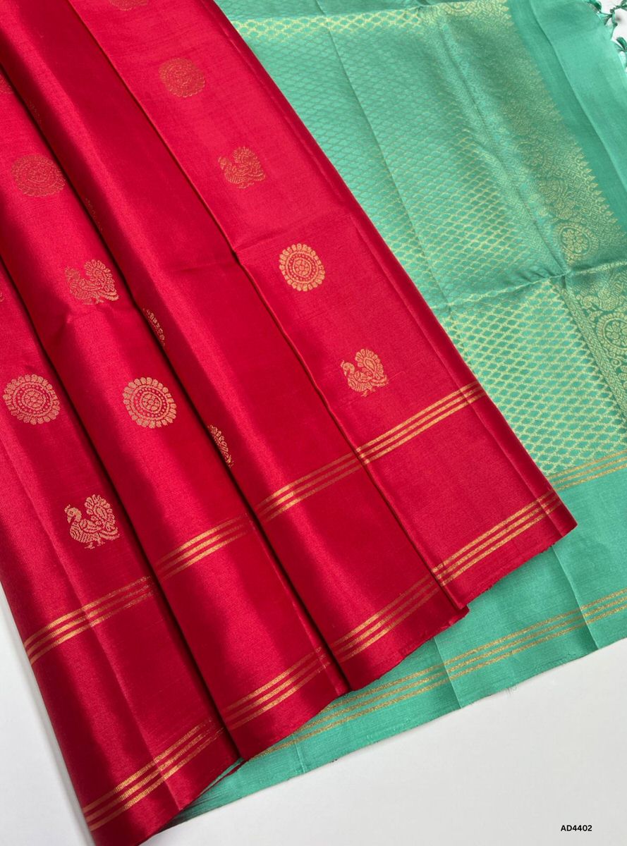 The Red & Mint Green Soft Silk Saree is a radiant handwoven creation that embodies festive charm and cultural richness. The red shade conveys devotion, prosperity, and celebratory brilliance, while the mint green contrast adds freshness, vibrance, and regal elegance. Enhanced with pure gold zari borders and a lustrous drape, this saree is perfect for weddings, temple ceremonies, and festive occasions. A timeless masterpiece, it blends bold vibrance with pastel sophistication in South Indian weaving traditio