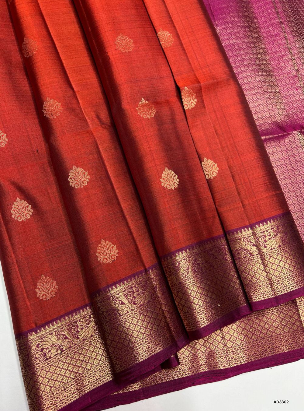 "Handwoven Rust Orange body with Dark Magenta pallu Bhutta Jacquard Border Soft Silk Saree featuring gold zari motifs and borders"