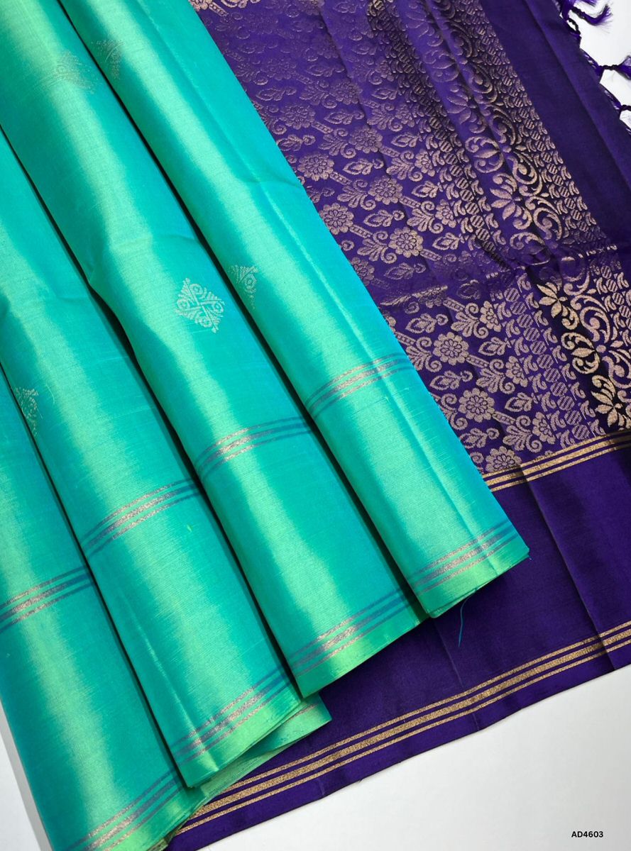 The Turquoise & Purple Bhutta Soft Silk Saree with Pure Gold Zari is a radiant handwoven creation that unites serene vibrance with regal depth, enriched by bhutta motifs, making it ideal for weddings, temple ceremonies, and festive occasions.