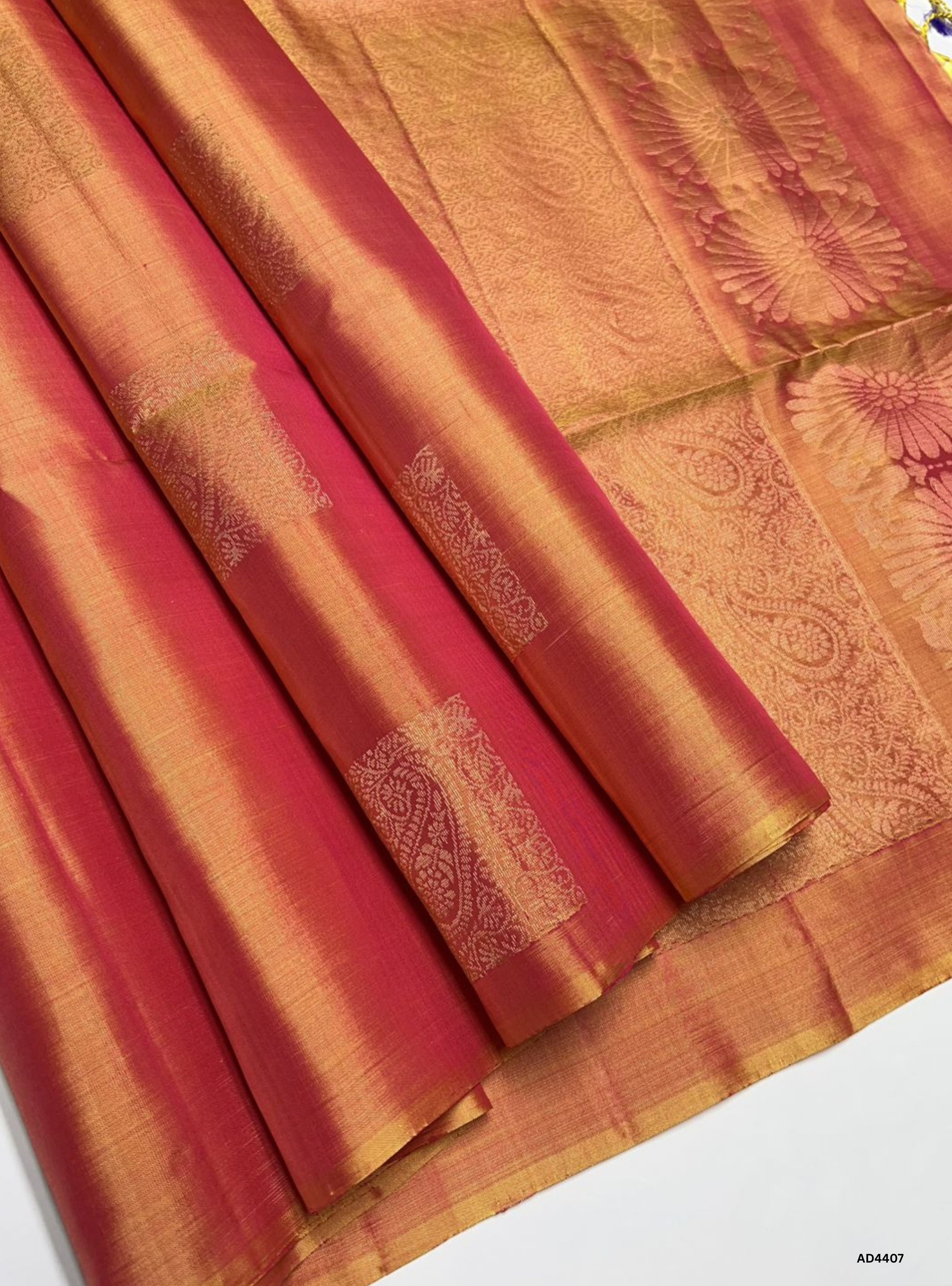 The Yellowish Pink Soft Silk Saree with Half Fine Tested Gold Zari and bhutta motifs is a radiant handwoven creation that combines festive warmth with delicate elegance, making it ideal for weddings, temple ceremonies, and cultural celebrations.