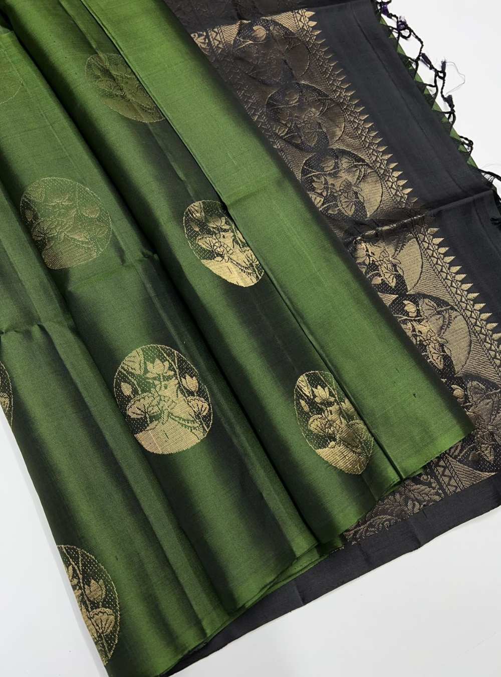 Dark Green and Black Soft Silk Saree with bhutta motifs and gold zari border, festive wear.